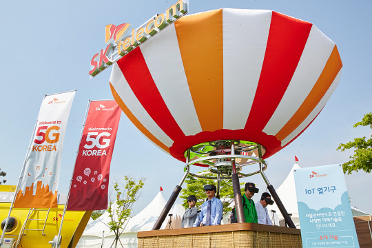 SK텔레콤은 18일부터 21일까지 인천 영종도 스카이72 골프앤리조트에서 'SK텔레콤 오픈'을 개최하고, 5세대(G) 이동통신 시대 실감형 미디어 서비스를 미리 경험할 수 있는 '5G 응용 서비스 체험 공간'을 운영한다고 밝혔다. 관람객들이 5G 열기구를 체험하고 있다. <SK텔레콤 제공>